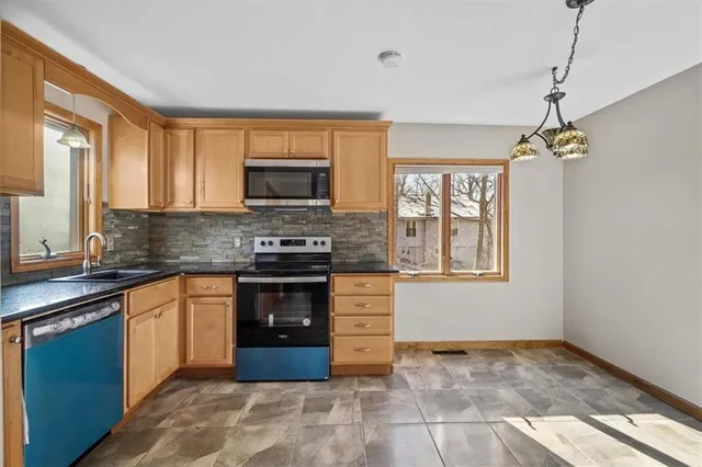 a kitchen with stainless steel appliances granite countertop a stove sink and microwave