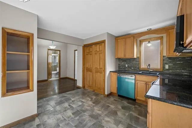 a kitchen with granite countertop a refrigerator and cabinets