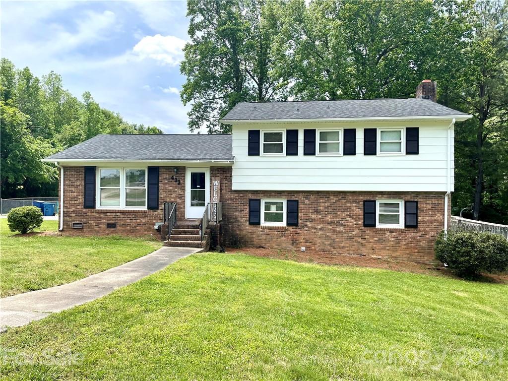 a front view of a house with a garden and yard