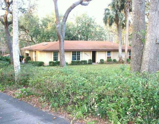 a front view of a house with a yard and trees