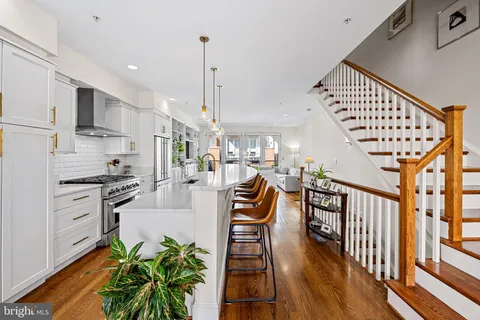a kitchen with stainless steel appliances granite countertop a stove and a wooden floors