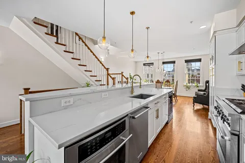 a bathroom with a granite countertop sink vanity mirror and toilet