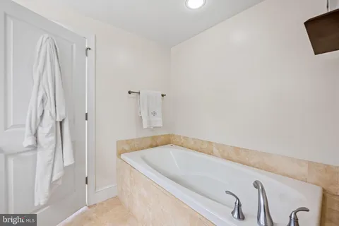 a bathroom with a granite countertop sink vanity mirror and toilet
