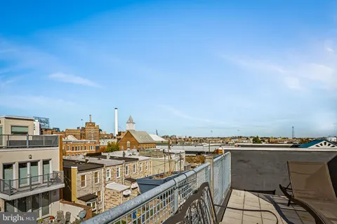 a kitchen with stainless steel appliances granite countertop a refrigerator a stove a sink a dining table and chairs with wooden floor