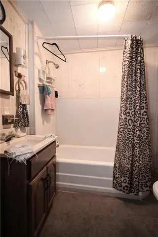 a bathroom with a granite countertop sink a toilet and shower