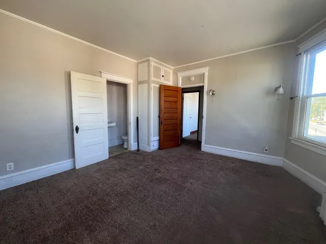 an empty room with windows and closet