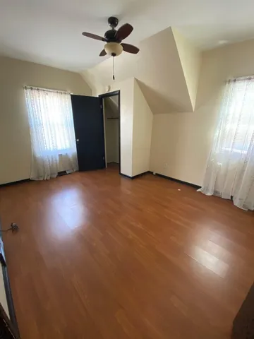 an empty room with windows and fan