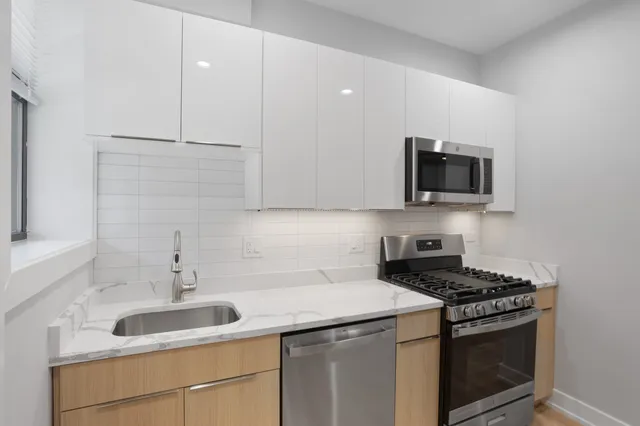 a kitchen with stainless steel appliances granite countertop a sink stove a microwave and cabinets