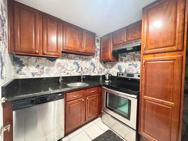 a kitchen with granite countertop stainless steel appliances and wooden cabinets