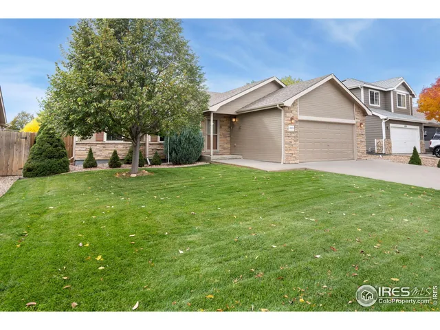 a view of a house with a yard and large trees