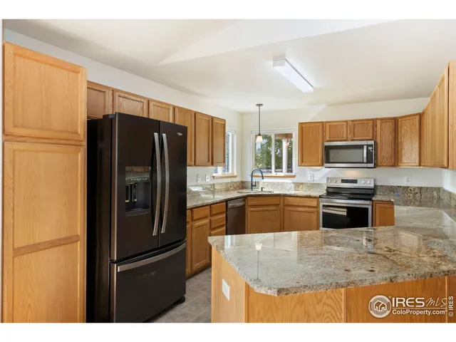 a kitchen with granite countertop a refrigerator and a sink
