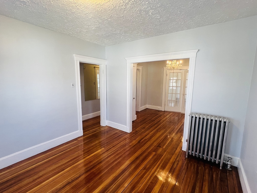 62 Westmore Road, Unit 2 Boston, MA 02126 - Photo 8 of 13 a view of a room with wooden floor and small window