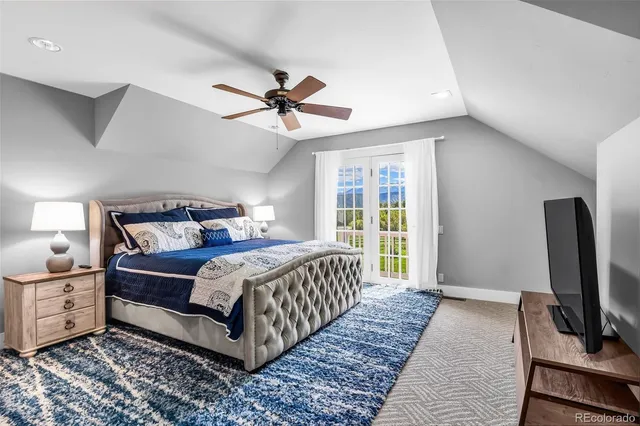 a bedroom with a bed a flat screen tv and a chandelier