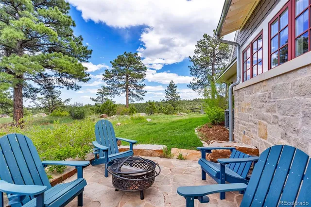 a view of a swimming pool and lounge chairs in back yard of the house