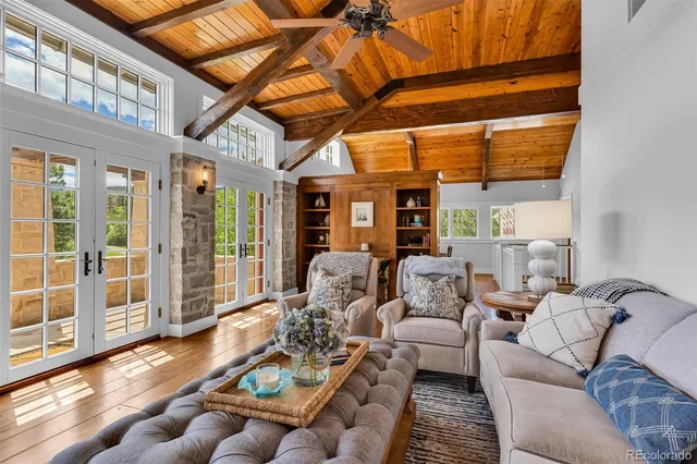 a living room with furniture with wooden floor and floor to ceiling windows