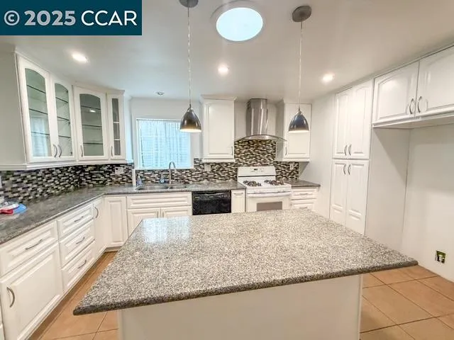 a kitchen with stainless steel appliances granite countertop a sink stove and cabinets