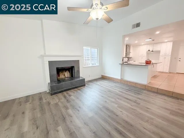 a view of a room with wooden floor and fire place