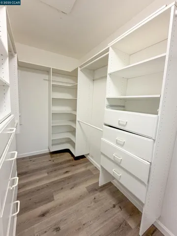 a view of walk in closet with empty racks