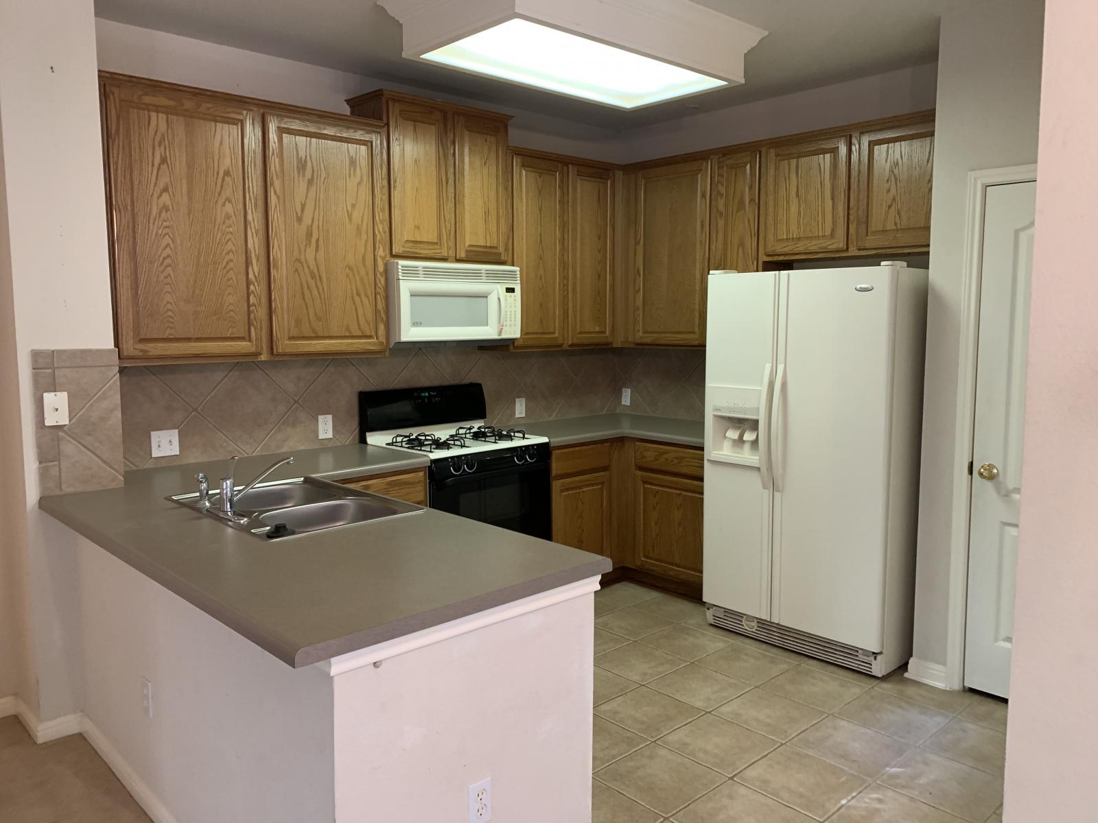 11000 Anderson Mill Road, Unit 29 Austin, TX 78750 - Photo 9 of 27 a kitchen with a refrigerator a stove top oven a sink and dishwasher