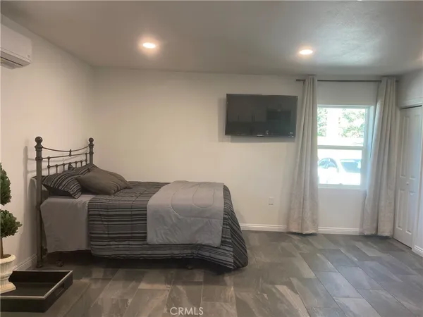a bedroom with a bed and a flat screen tv