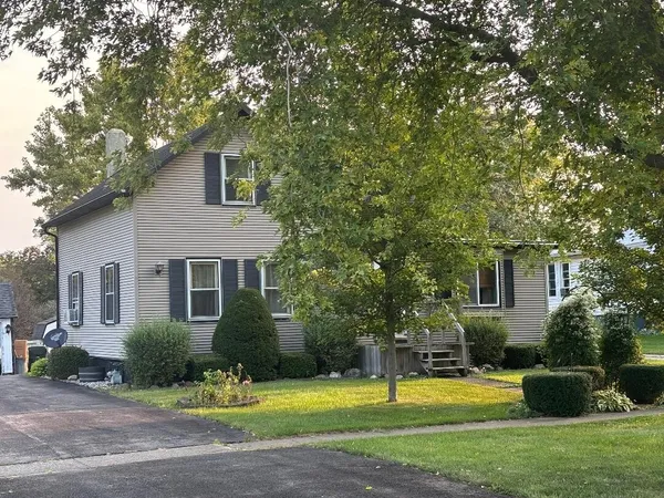 a front view of a house with a yard and trees