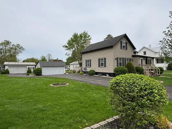 a front view of a house with a yard and trees