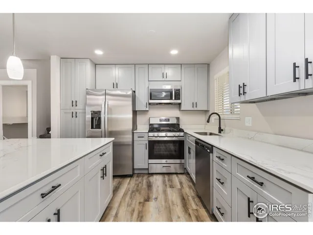 a kitchen with kitchen island white cabinets and stainless steel appliances