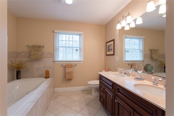 34 Bellflower Street Lexington, MA 02421 - Photo 13 of 21 a bathroom with a double vanity sink a toilet a mirror and bathtub