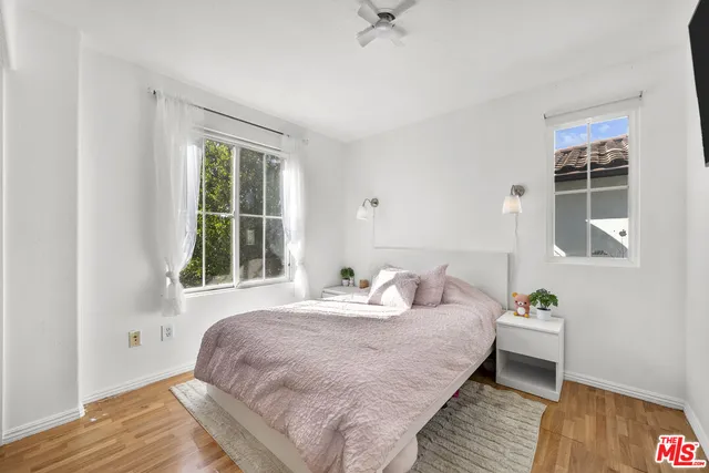 a bedroom with a bed wooden floor and a window