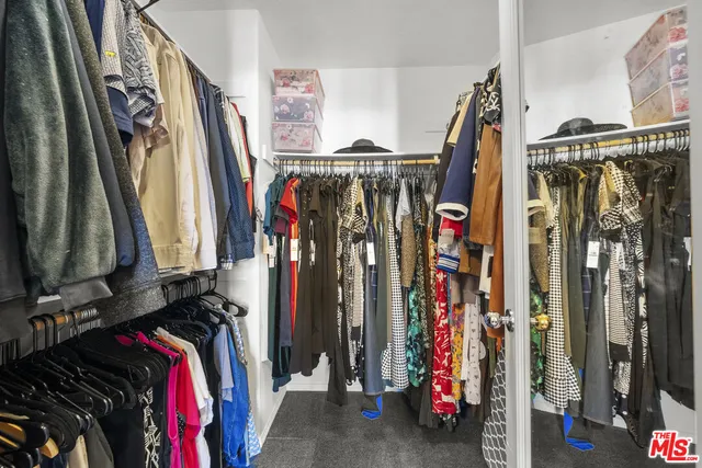 a view of walk in closet with clothes