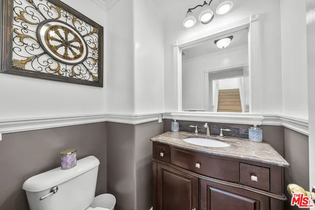 a bathroom with a sink mirror vanity and toilet