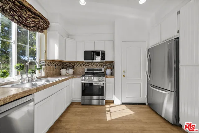 a kitchen with granite countertop a refrigerator and a sink