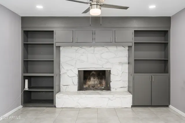 an empty room with windows and ceiling fan