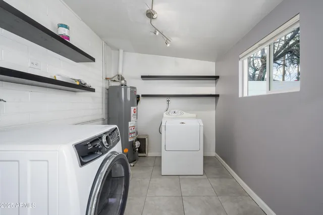 an empty room with chandelier fan and windows