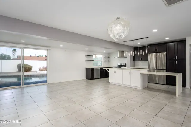 a large white kitchen with a sink and a large window
