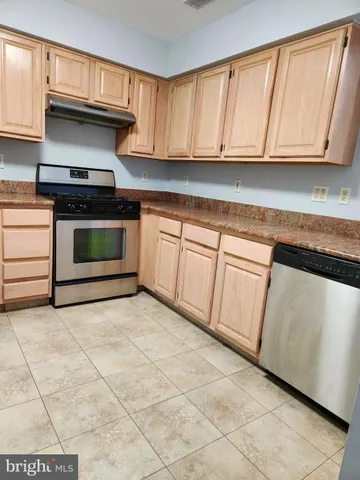 a kitchen with granite countertop a stove a sink and a microwave