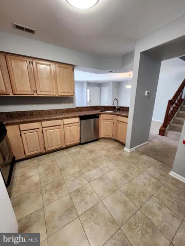 a large kitchen with a stove a sink dishwasher and a refrigerator