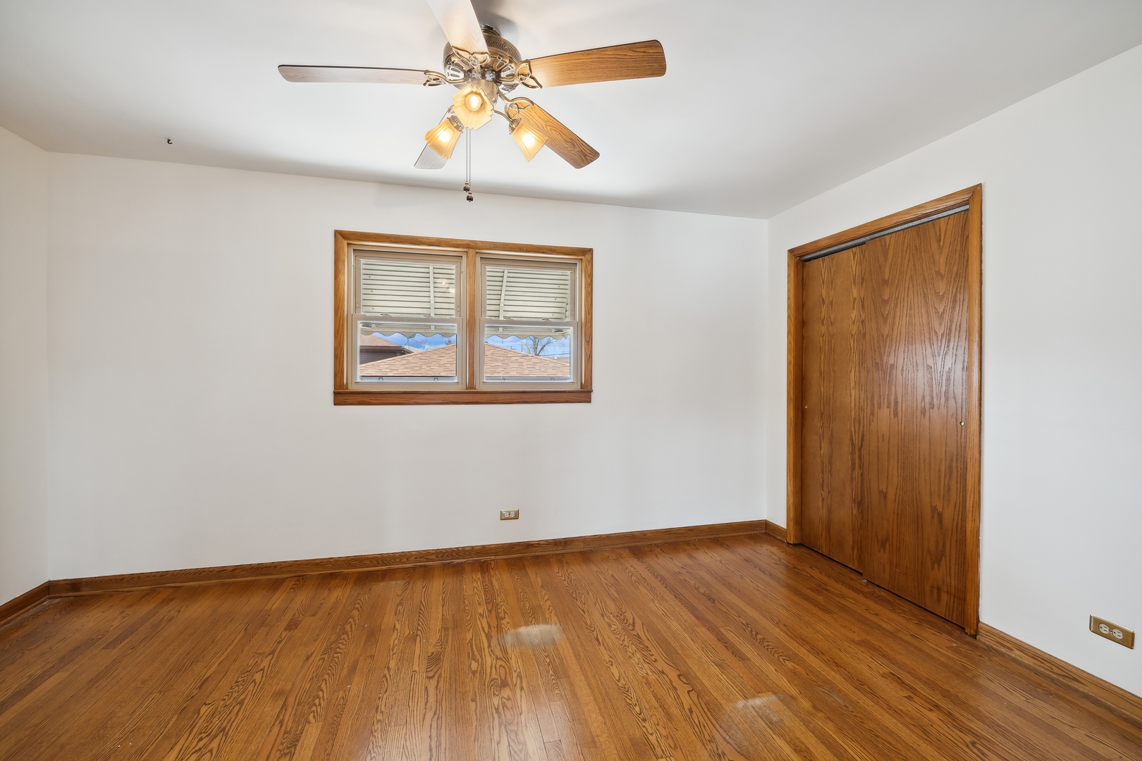 6741 West 59th Street Chicago, IL 60638 - Photo 10 of 16 a view of an empty room with wooden floor and a ceiling fan