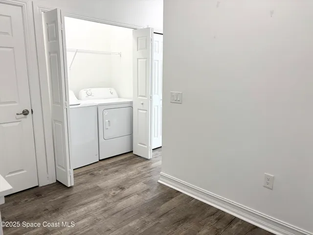 an empty room with wooden floor and mirror