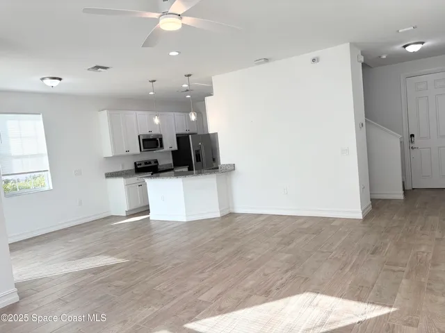a view of kitchen with wooden floor and electronic appliances