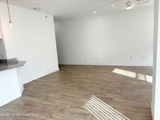a view of an empty room window and wooden floor