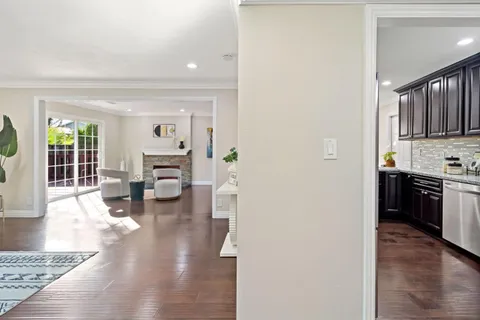 a kitchen with stainless steel appliances granite countertop wooden cabinets a sink a stove a dining table and chairs