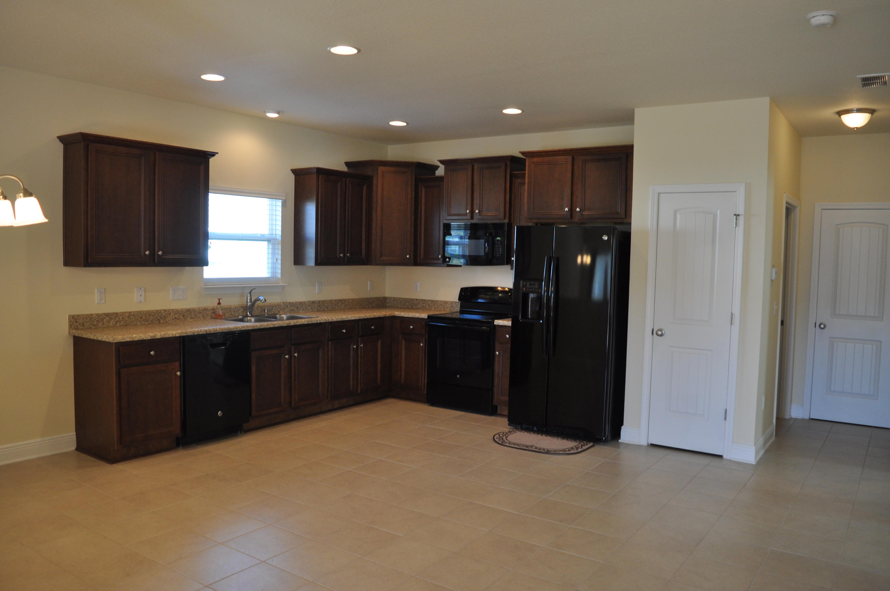 46 Nelly Street Freeport, FL 32439 - Photo 4 of 16 a kitchen with a refrigerator and a sink