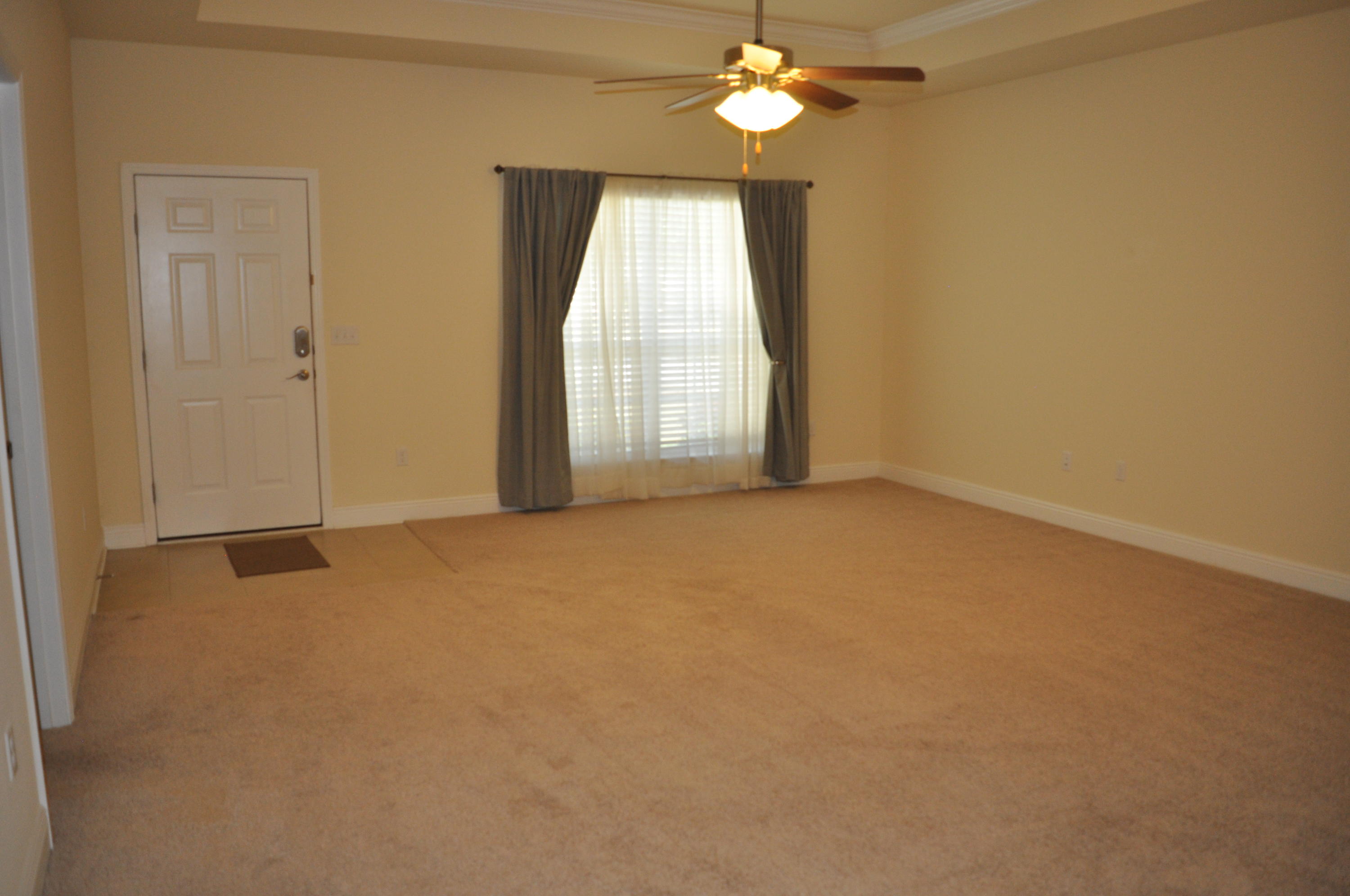 46 Nelly Street Freeport, FL 32439 - Photo 6 of 16 an empty room with a chandelier fan and windows