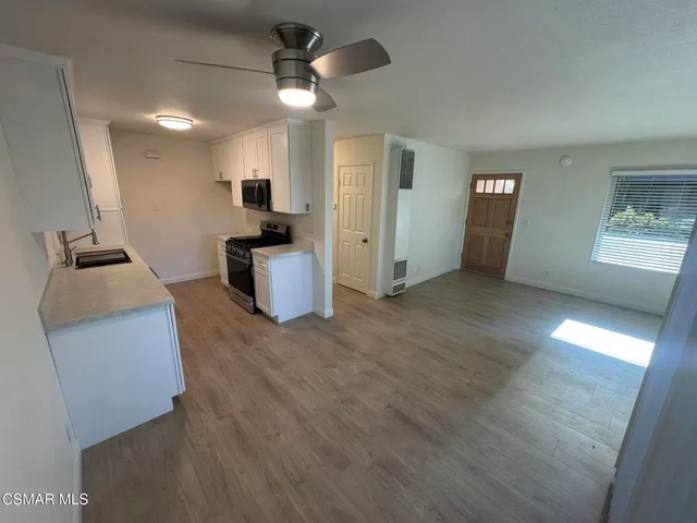 a view of a kitchen with a sink dishwasher oven and a refrigerator