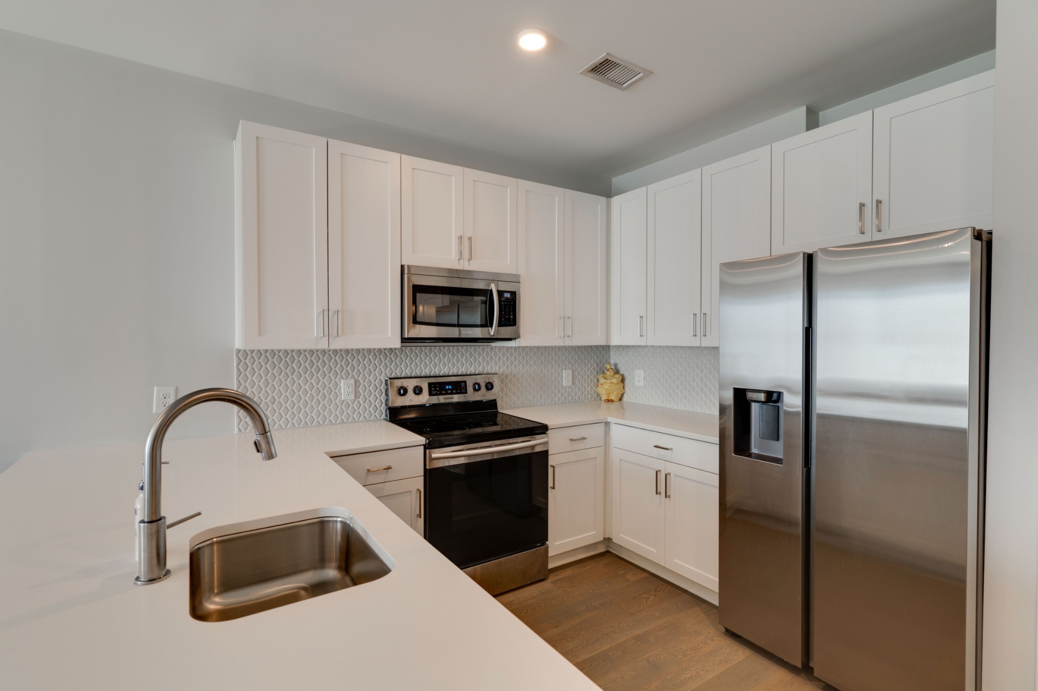 1041 East Trinity Lane, Unit 315 Nashville, TN 37216 - Photo 12 of 48 a kitchen with white cabinets and stainless steel appliances