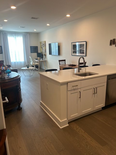 1041 East Trinity Lane, Unit 315 Nashville, TN 37216 - Photo 5 of 48 a large white kitchen with cabinets a sink a window and chairs