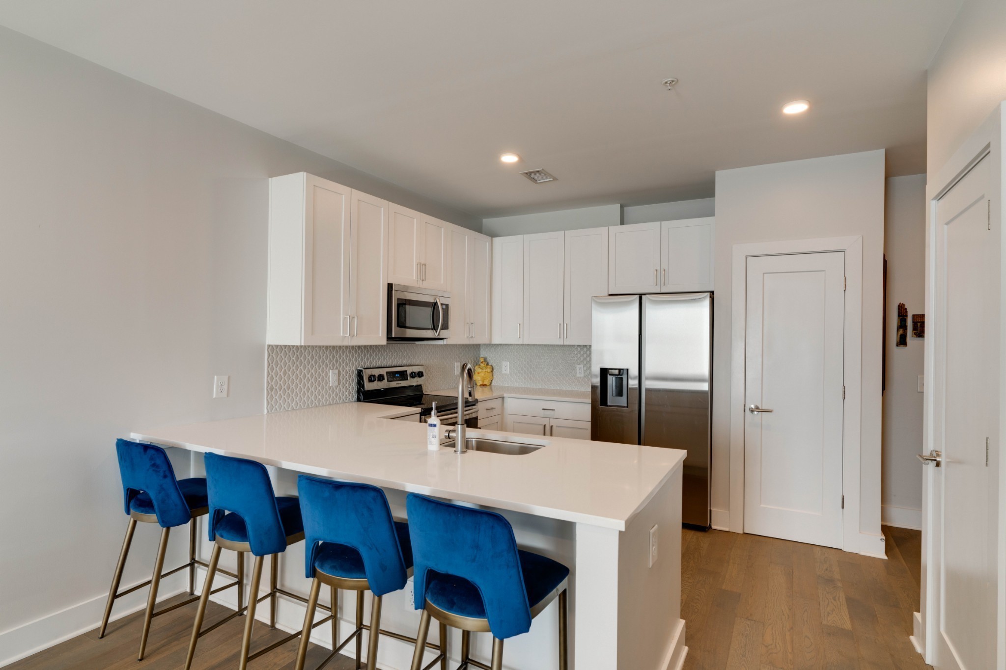 1041 East Trinity Lane, Unit 315 Nashville, TN 37216 - Photo 7 of 48 a kitchen with stainless steel appliances a sink a stove a refrigerator with white cabinets and wooden floor