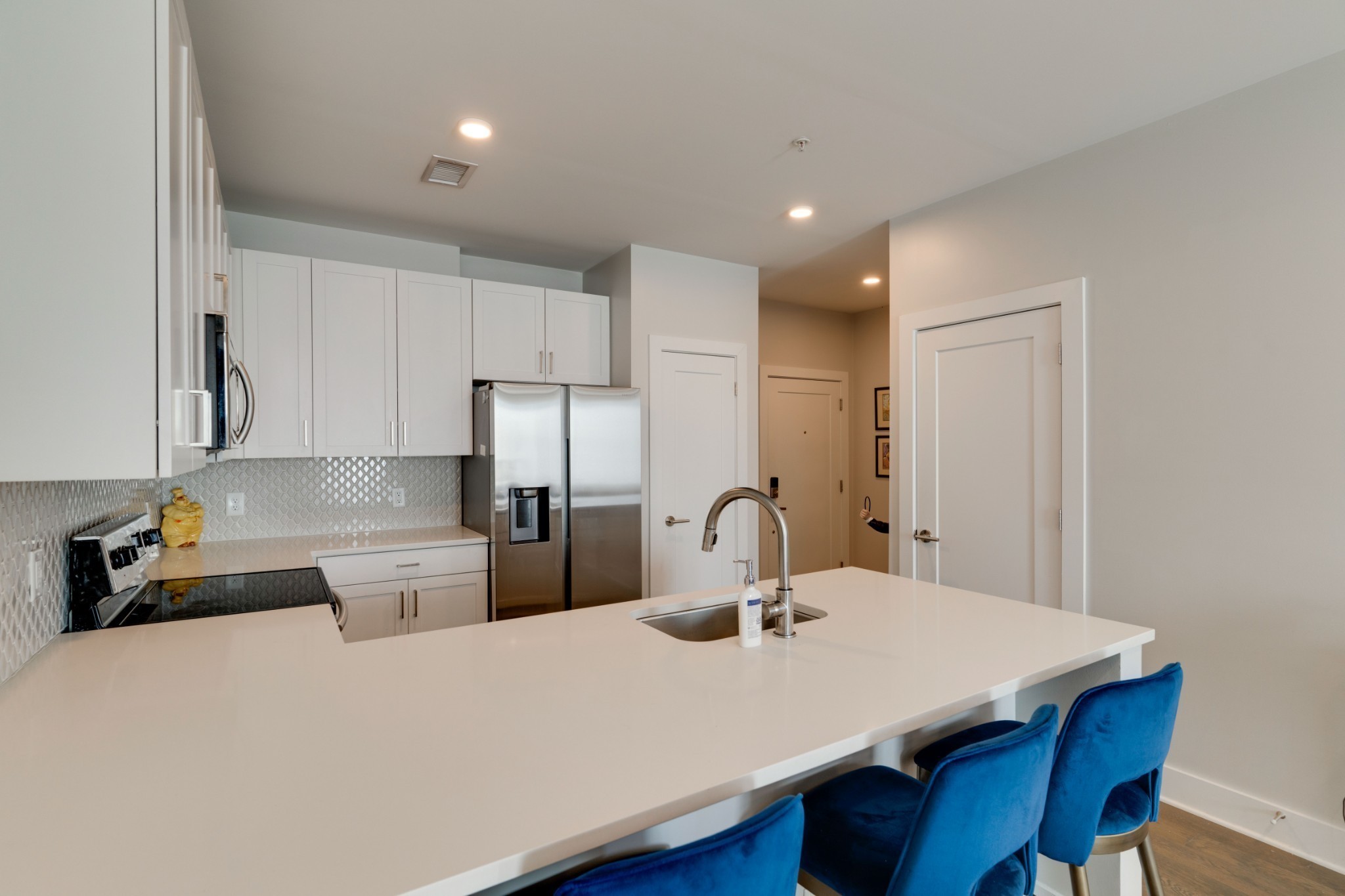 1041 East Trinity Lane, Unit 315 Nashville, TN 37216 - Photo 10 of 48 a kitchen with a dining table chairs and white cabinets