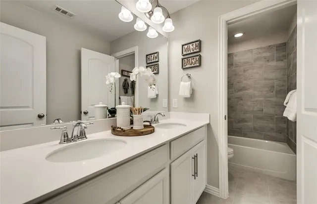 a bathroom with a sink double vanity granite tub and a mirror